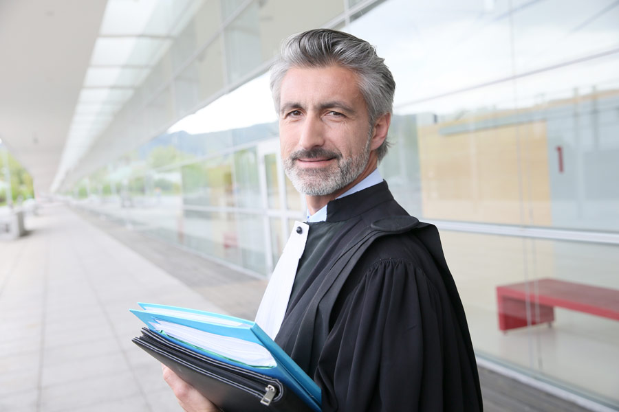 Portret prawnika stojącego przed budynkiem sądu.